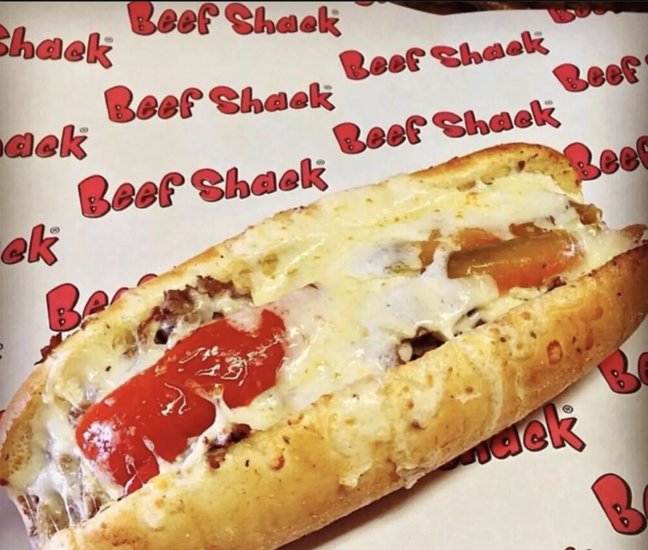 A Cheezy Beef sandwich on garlic bread, open on Beef Shack wrapping paper